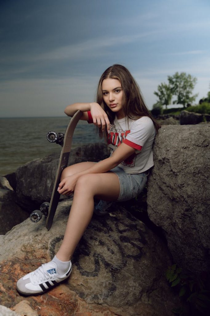 Woman in Shorts and T-shirt Holding Skateboard